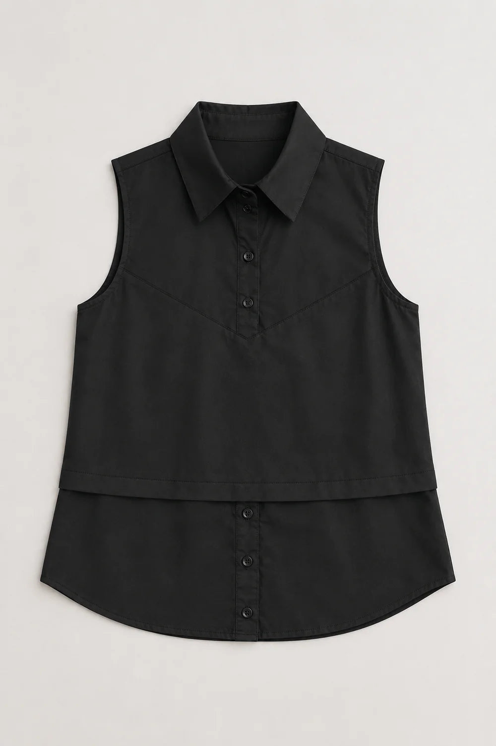 Caroline sleeveless black collared shirt with button placket and layered hem detail.