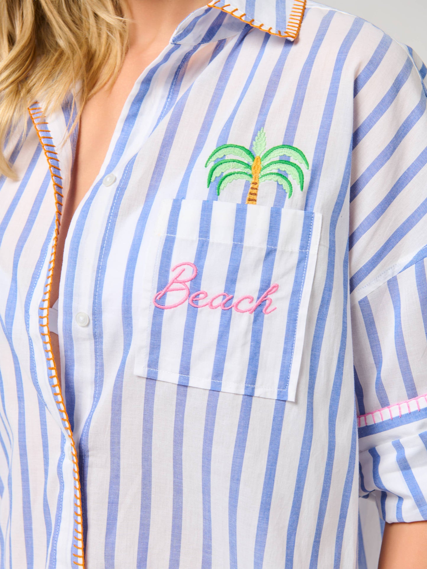 Shiraleah Beach Ocean Air Cover-Up Shirt close-up: blue-white stripes, chest pocket with embroidered palm tree and 'Beach' in pink.