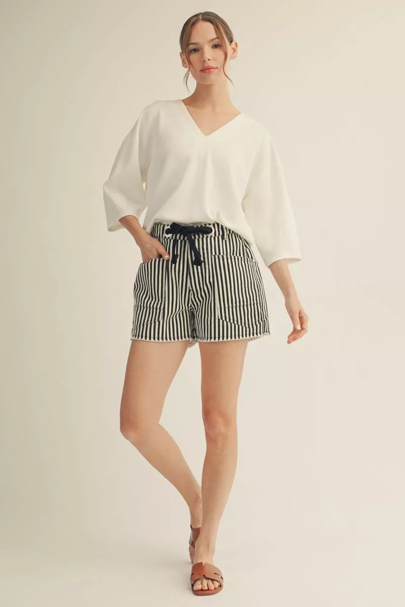Cloud Kiss Top: white V-neck oversized tee with three-quarter length wide sleeves, worn with striped shorts.