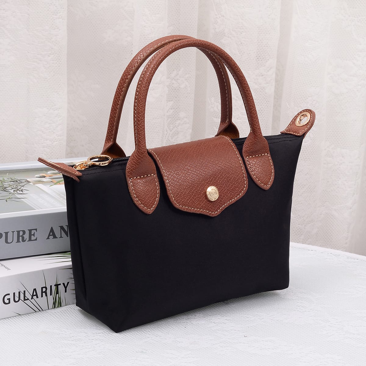 Britney Nylon Double Handle Crossbody Bag in Black with brown leather handles and gold hardware accents.
