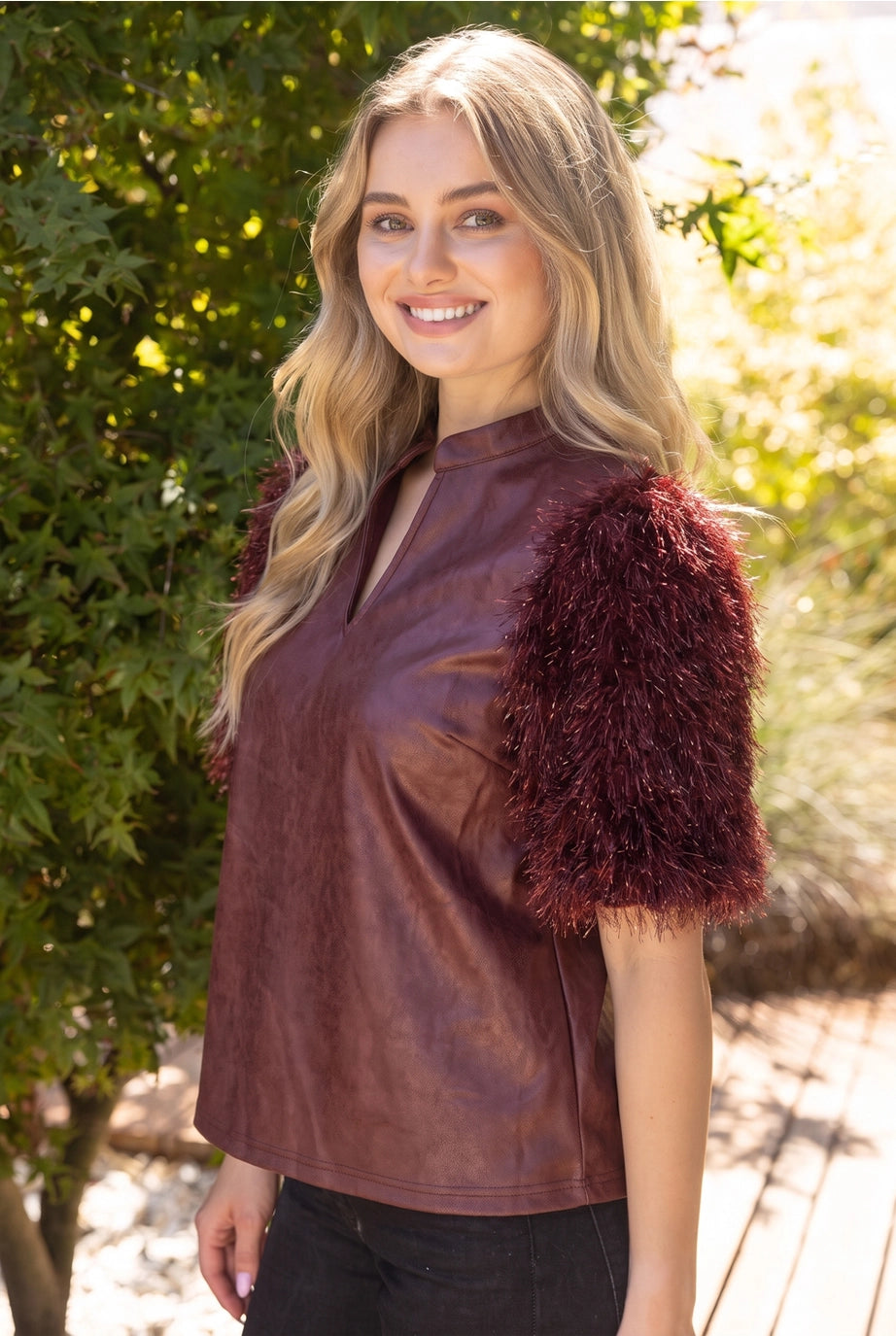 The Faux Feather Top Burgundy by The Faux Feather, featuring faux leather body with fluffy feather-trim short sleeves and ...