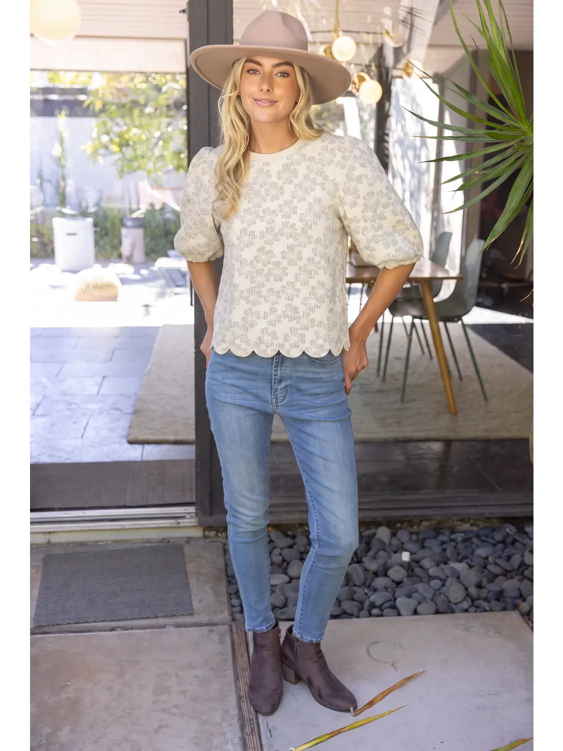 The Willow Bloom scalloped-hem textured knit top with puff sleeves, styled with skinny jeans and ankle boots.