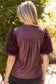 The Faux Feather Top Burgundy featuring a faux leather back with fluffy feather-textured short sleeves.