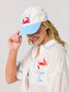 White and blue Crab Ball Cap featuring embroidered red crab stamp patch on structured dad hat.