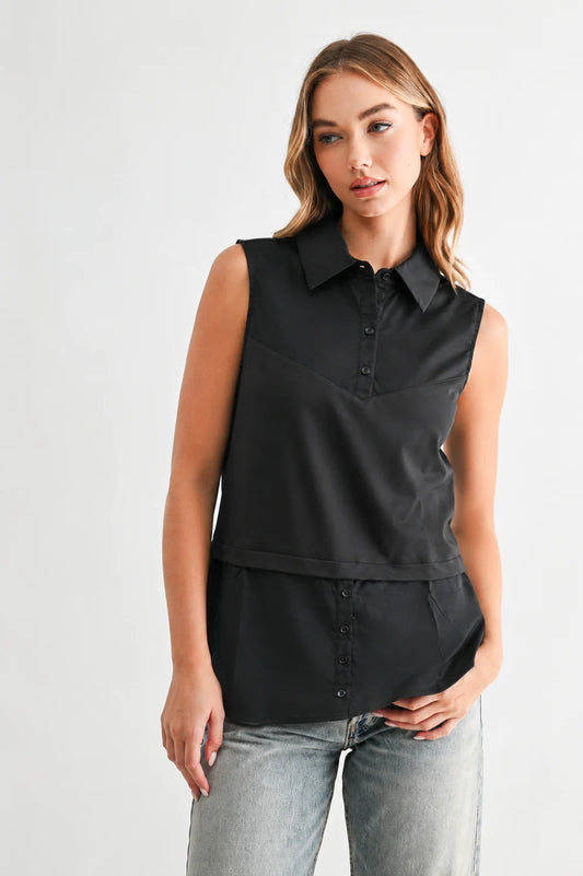 Caroline sleeveless black collared button-down top with layered hem detail, paired with light wash jeans.
