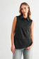 Caroline sleeveless black collared button-down top with layered hem detail, paired with light wash jeans.