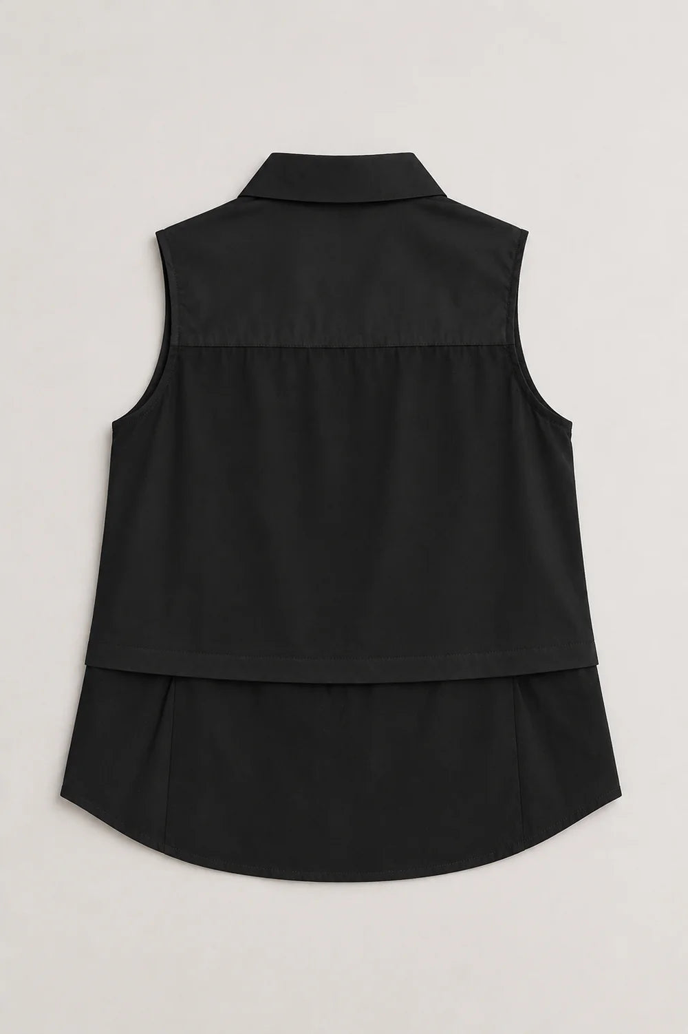 Caroline black sleeveless collared top with layered back detail and curved hem.