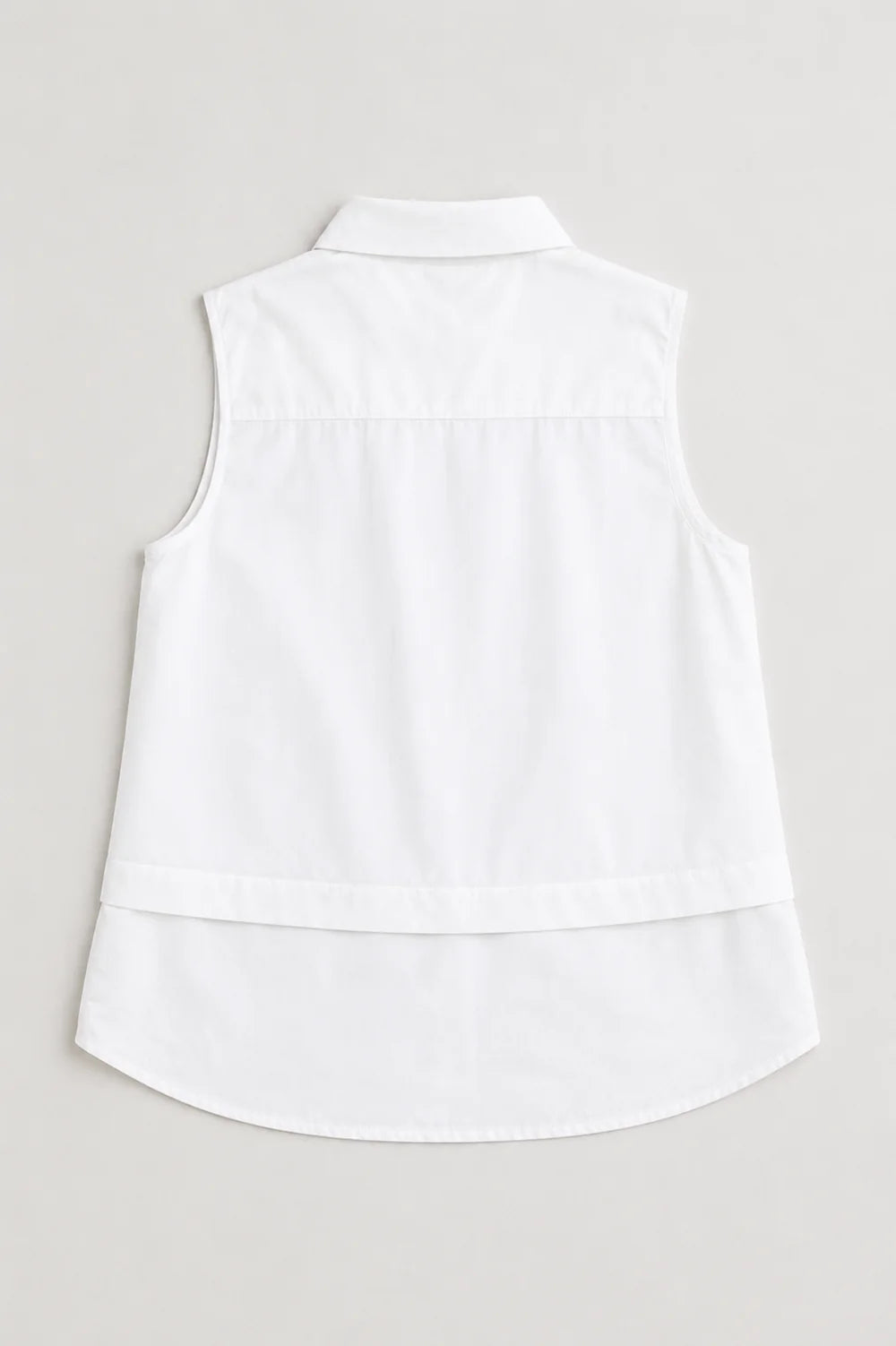 Caroline sleeveless white collared shirt top with curved hem and back yoke detail.