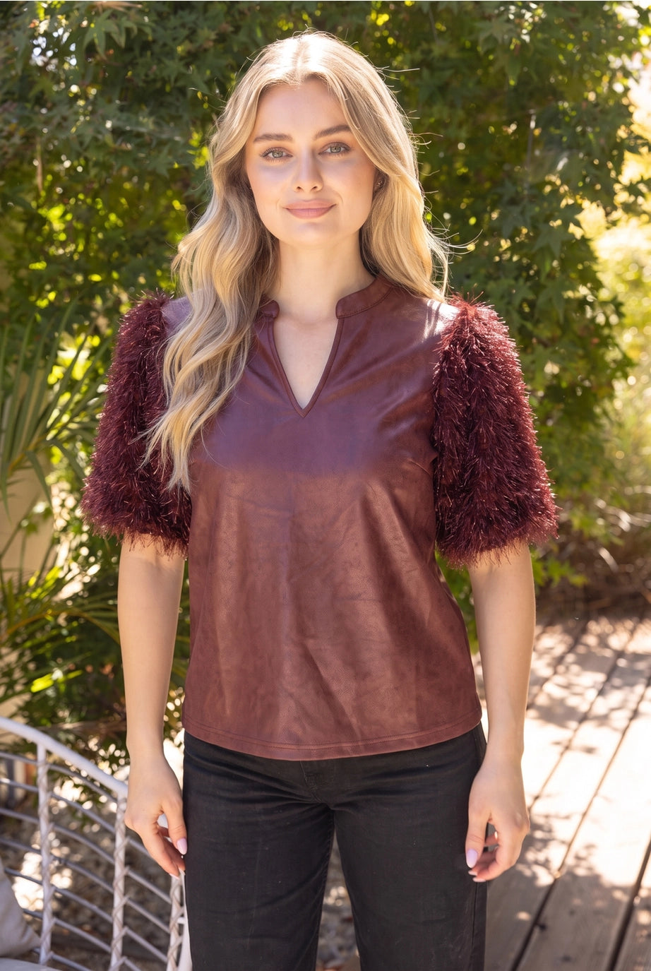 The Faux Feather Top Burgundy by The Faux Feather, featuring a faux leather body with fluffy feather-textured puff sleeves...