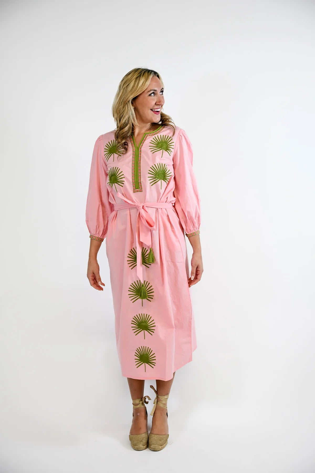 Victoria Dunn Quinn Dahlia pink midi dress with green embroidered palm leaf motifs, tie belt, and balloon sleeves.