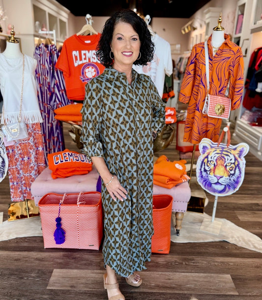 Boho Chic Dessert Dream Dress in olive green geometric print, button-front midi length, worn by model in boutique setting.