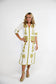 Victoria Dunn Esme white midi dress with olive green palm tree embroidery, tassel ties, and three-quarter sleeves.