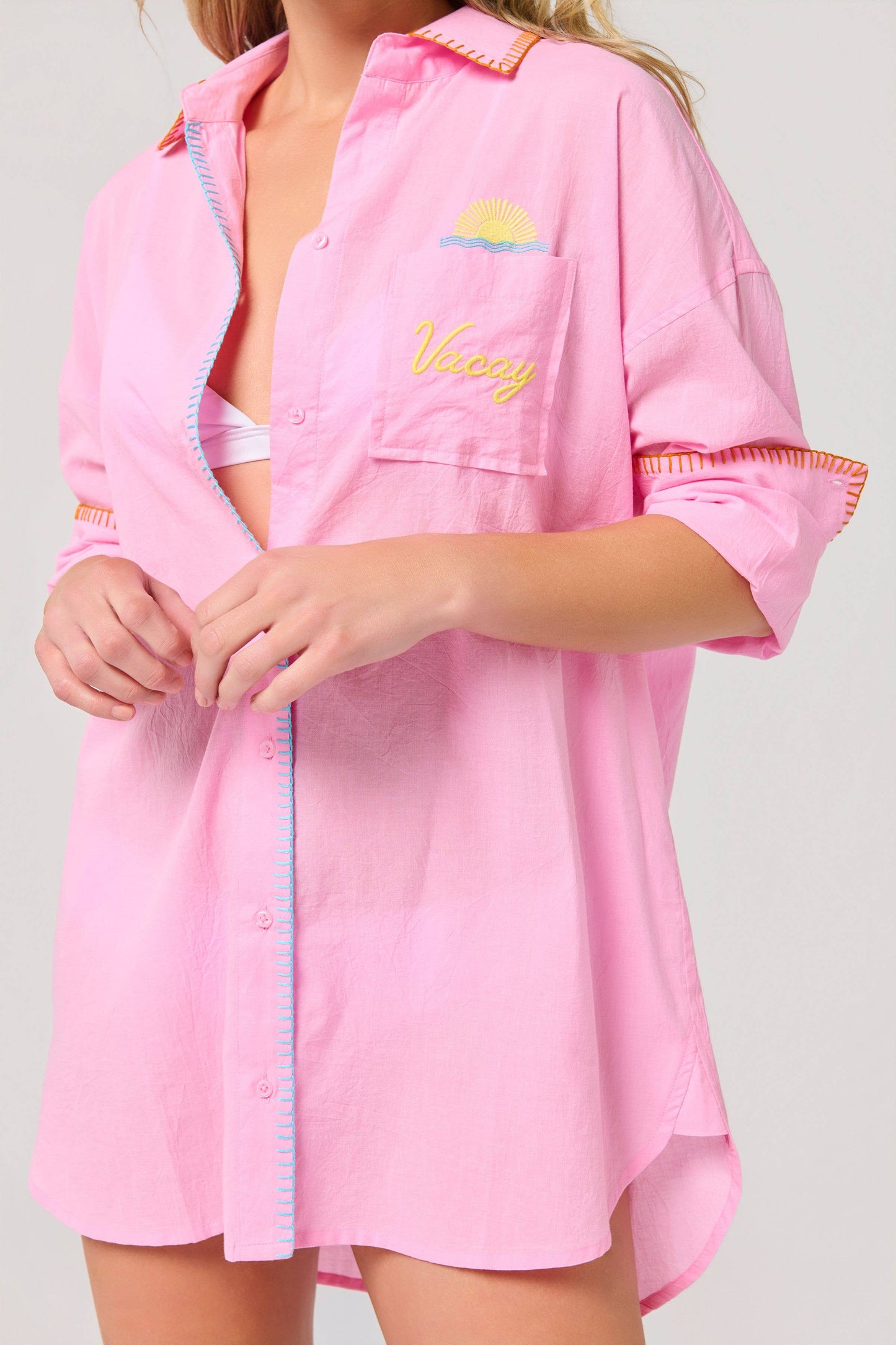 Vacay Out Of Office pink oversized button-up cover-up shirt with embroidered sunset logo and colorful stitching details.