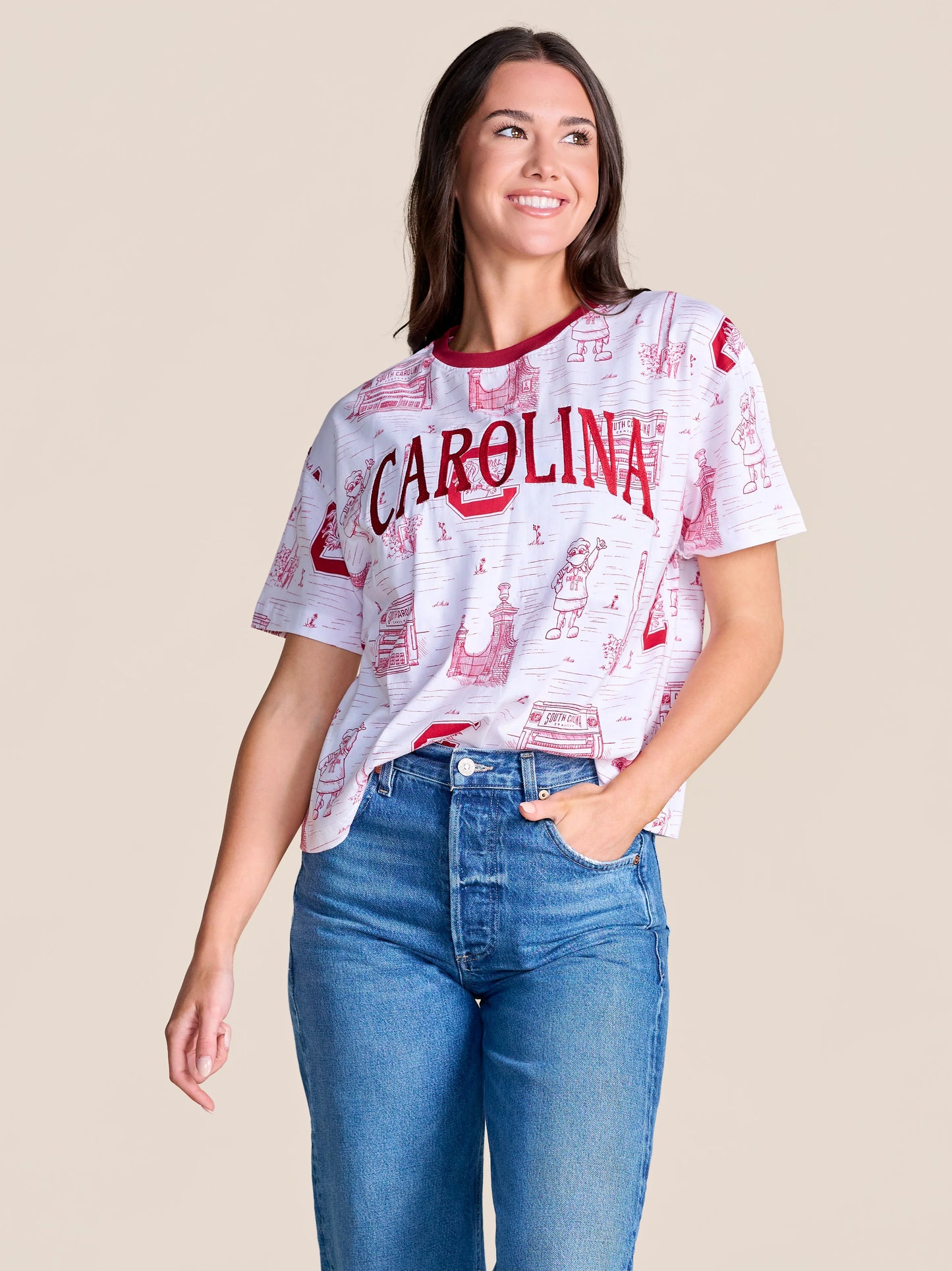 Stewart Simmons Team Toile Embroidered Tee featuring "Carolina" text with illustrated campus scenes on white fabric.