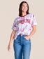 Stewart Simmons Team Toile Embroidered Tee featuring "Carolina" text with illustrated campus scenes on white fabric.