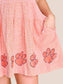 Stewart Simmons Good Sport Seersucker Dress Clemson close-up showing orange gingham fabric, sequin paw print hem, and side pocket.