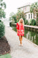 Victoria Dunn Presley red shift dress with white palm tree embroidery, worn with neutral platform sandals outdoors.