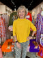 Maple Mockneck Sweater in mustard yellow with ribbed collar and short sleeves, worn by smiling woman.
