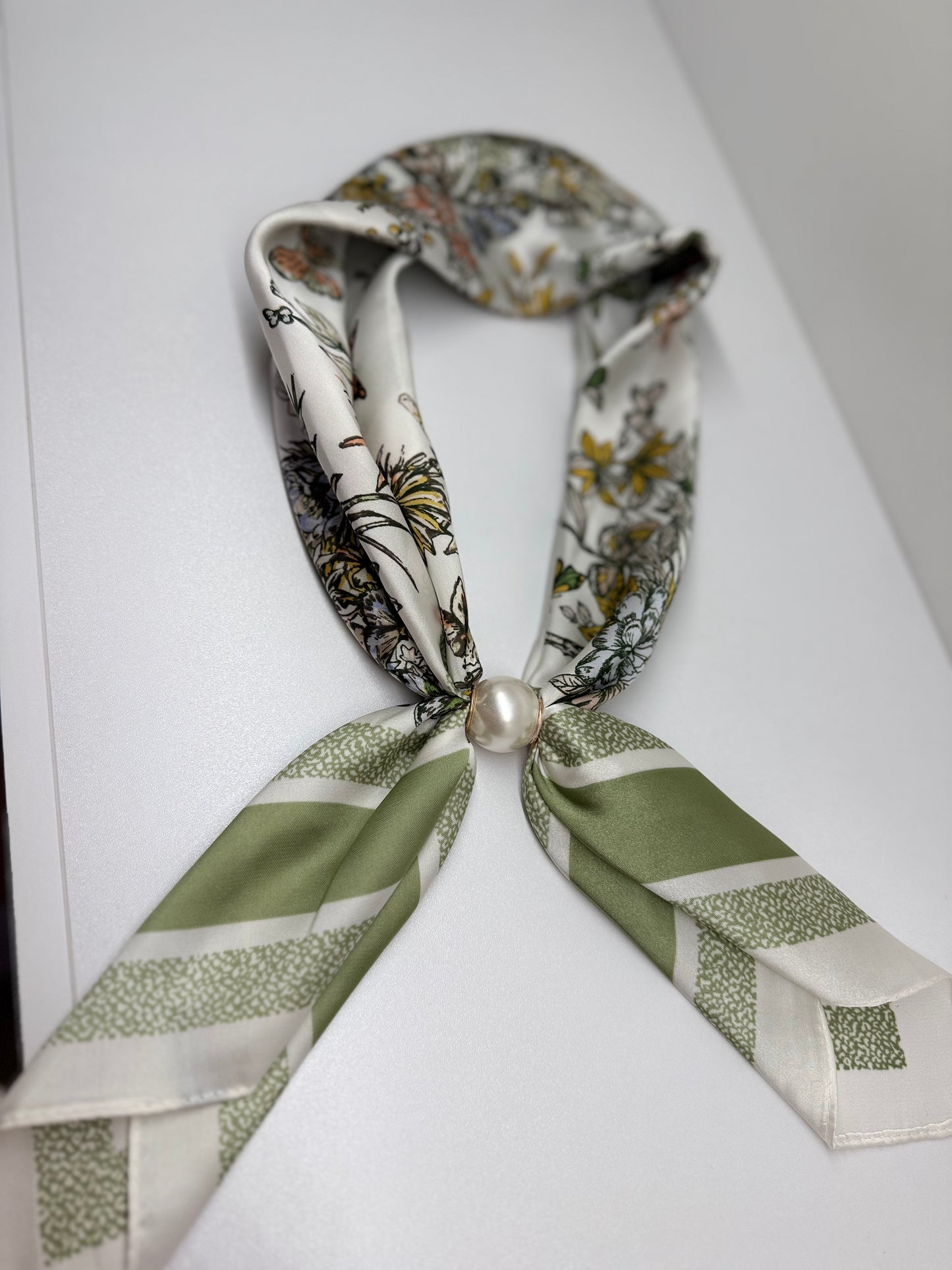 Ready To Wear magnetic scarf with floral print, sage green striped ends, and pearl clasp closure.