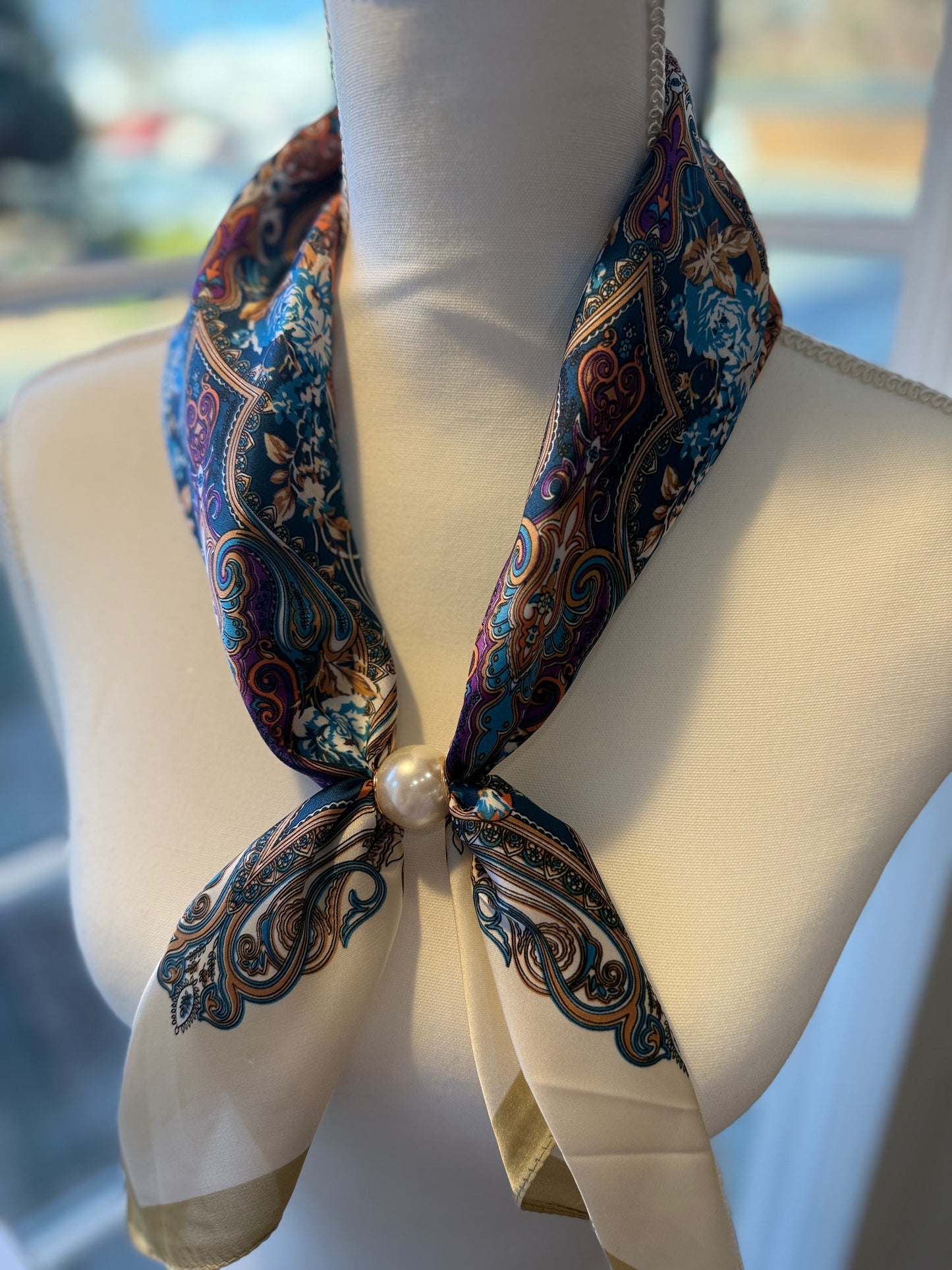 Ready To Wear magnetic scarf with paisley print and pearl closure draped on mannequin.