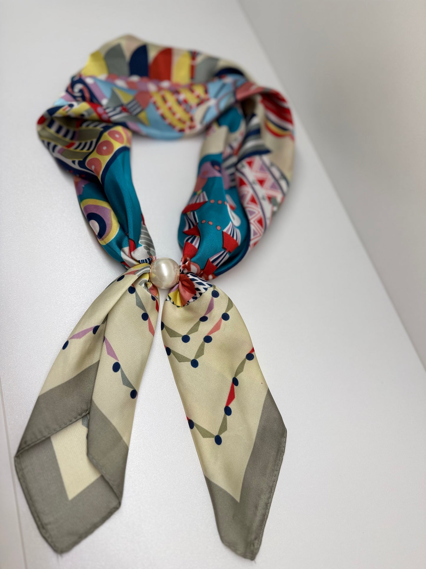 Ready To Wear magnetic silk scarf with multicolor geometric print, gathered with a pearl closure detail.