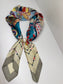 Ready To Wear magnetic silk scarf with multicolor geometric print, gathered with a pearl closure detail.