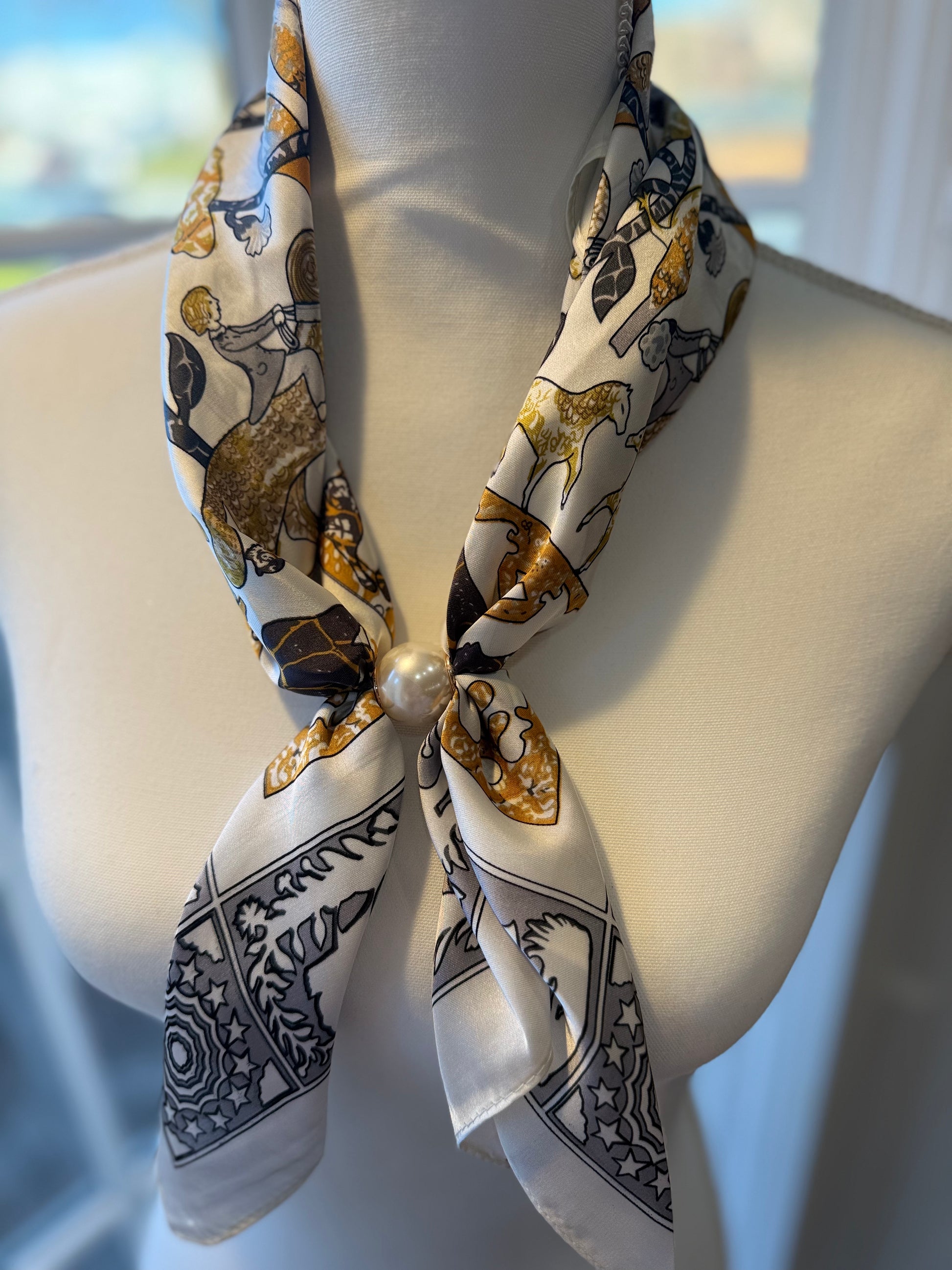 Ready To Wear Magnetic Scarf with equestrian print and pearl magnetic closure on mannequin.