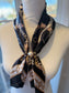 Ready To Wear magnetic scarf with chain print draped on mannequin, secured with large pearl accent.