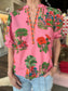 Maude Vivante Raya Top Pink Isles — pink short-sleeve blouse with vibrant botanical embroidery and V-neckline trim.