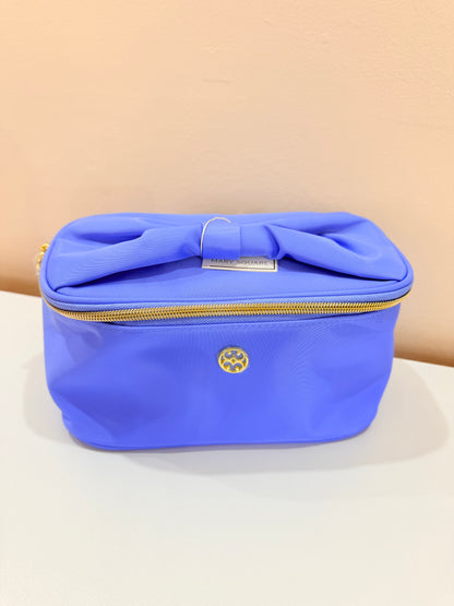 Mary Square periwinkle blue cosmetic bag with bow detail, gold zipper, and logo emblem.