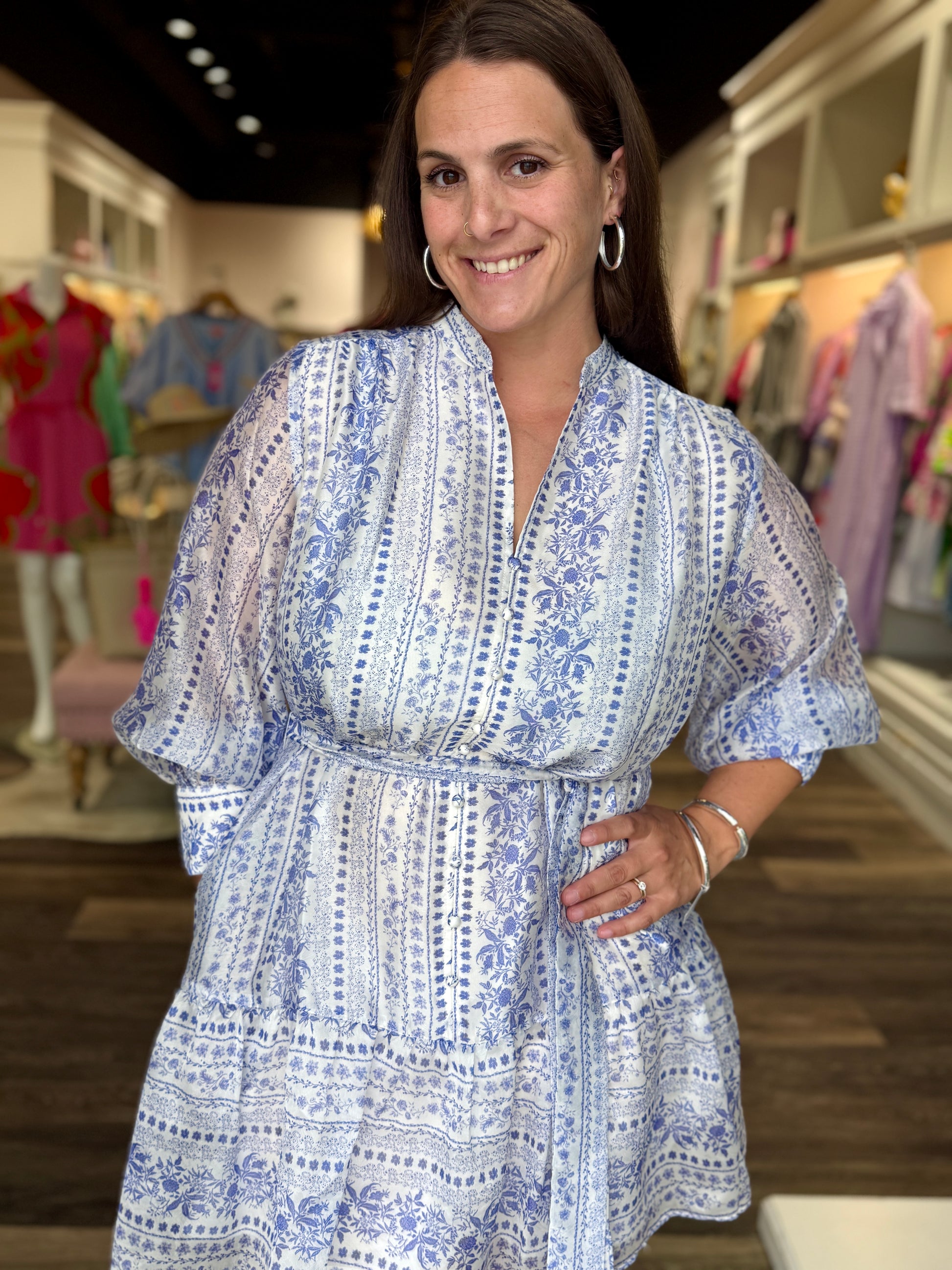 Joy Joy Porcelain Garden Dress featuring blue and white floral print, flutter sleeves, and tiered silhouette worn by smili...