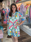 House of MBR Mint Chinois Shirt Dress Short, mint green with pink birds, lemons, and florals, modeled front view in boutique.