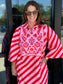 Maude Vivante Sophia Scarlet Slash Dress featuring red and pink diagonal stripes with tropical embroidered bib neckline.
