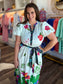 Maude Vivante Nova Dress Forest Flutter — white midi dress with colorful floral and bird embroidery, black belted waist, s...