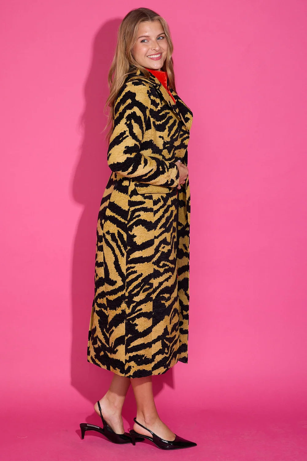 Alden Adair Darby Coat Noir Cat: a long tiger-print coat with black slingback heels and red collar detail.