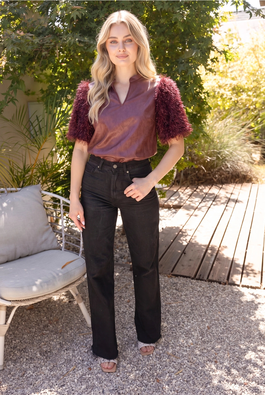 The Faux Feather Top Burgundy by The Faux Feather, featuring a satin-look bodice with textured feathery sleeves.