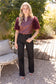 The Faux Feather Top Burgundy by The Faux Feather, featuring a satin-look bodice with textured feathery sleeves.
