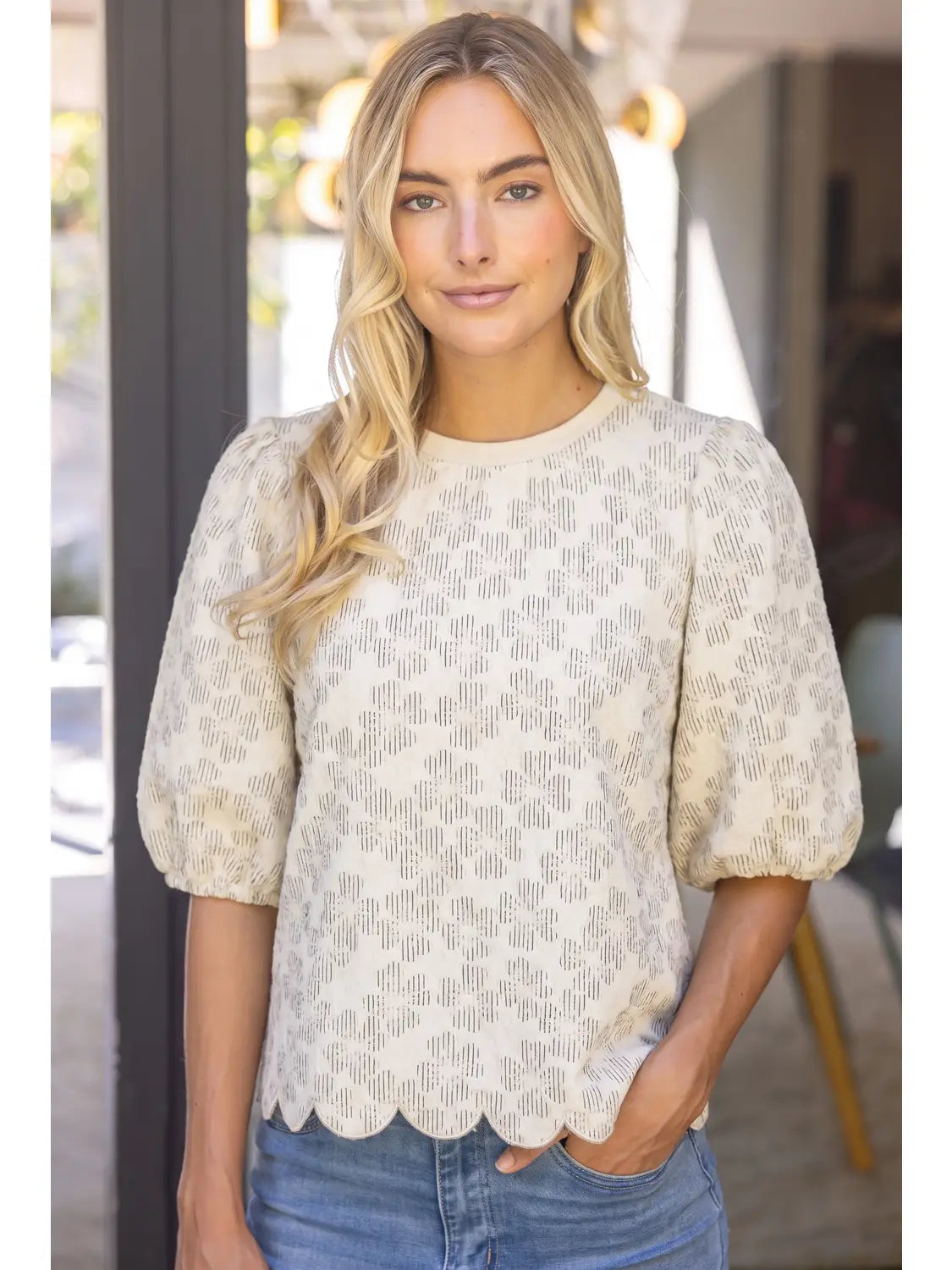The Willow Bloom scalloped hem top with puff sleeves, textured pattern, and crew neckline.