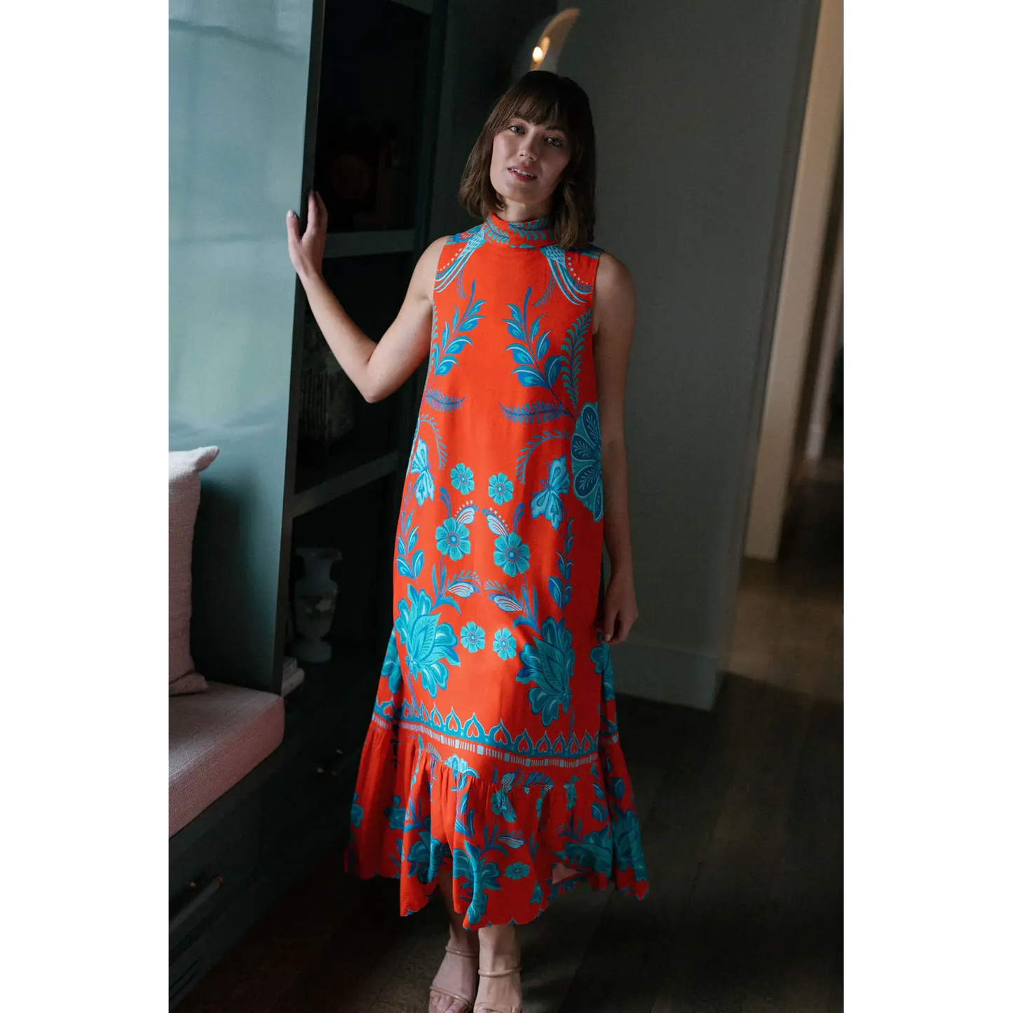 Briton Court Strawberry Waves Charlie Maxi Dress in vibrant orange with turquoise floral print and ruffled hem.