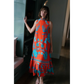 Briton Court Strawberry Waves Charlie Maxi Dress in vibrant orange with turquoise floral print and ruffled hem.