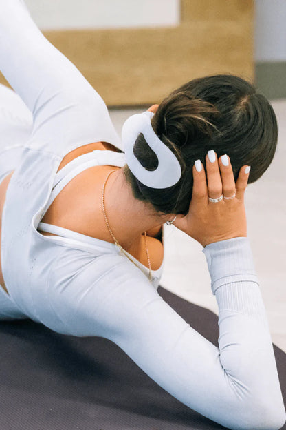 Teleties Flat Round Hair Clip in Coconut White securing a dark updo bun during yoga practice.
