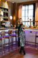 Alden Adair Scout Dress Wild Silhouette — dark green midi dress with bold black-and-white zebra print panel, worn by model at upscale bar