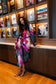 Alden Adair Bronte Dress Solar Vines: model wearing bold multicolor abstract print midi dress with belt and long sleeves, front view.