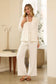 White high-waisted wide-leg trousers styled with matching blazer and camisole on standing female model.