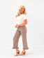 EE Some Gingham Ruffle Hem Pants in brown check print, cropped length with ruffle cuffs, styled on model with white top.