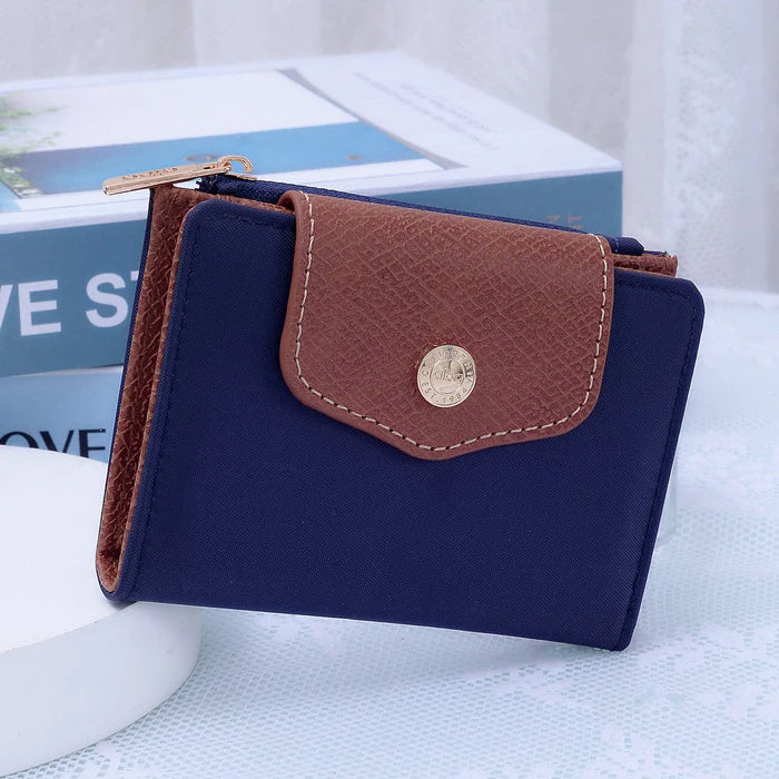 MiMi Wholesale Stephie Nylon Snap Bifold Wallet in navy blue with brown faux leather flap, gold snap closure, and zipper pull.