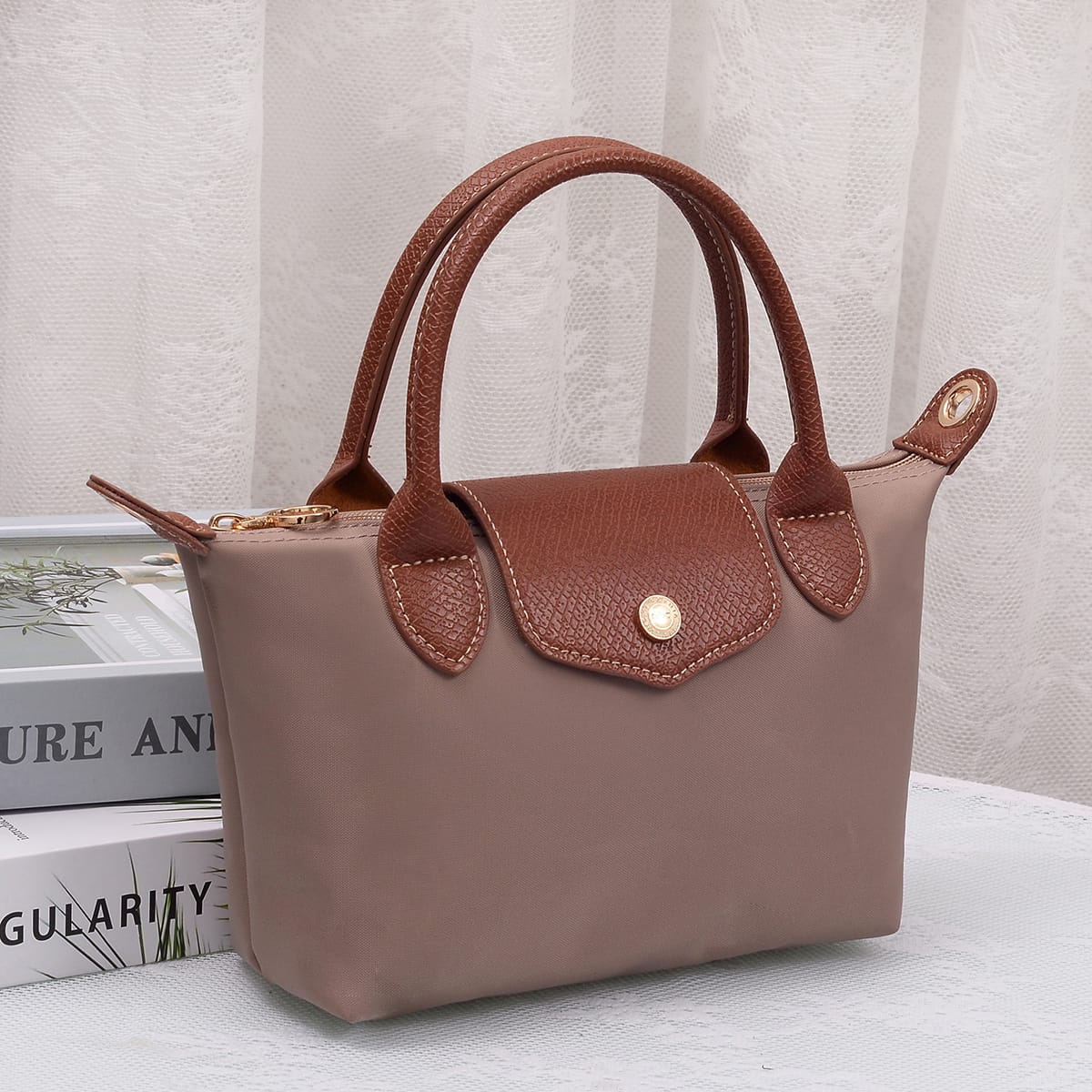 Britney Nylon Double Handle Crossbody Bag in Taupe with brown leather handles and gold snap closure.