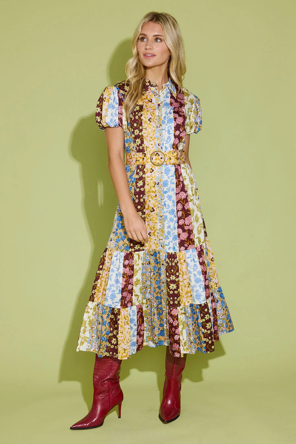 Alden Adair Luna Dress Golden Bouquet: model wearing patchwork floral midi dress with belt and red cowboy boots, front view.
