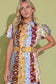 Alden Adair Luna Dress Golden Bouquet: model wearing patchwork floral shirtdress with puff sleeves and wide belt, front view.