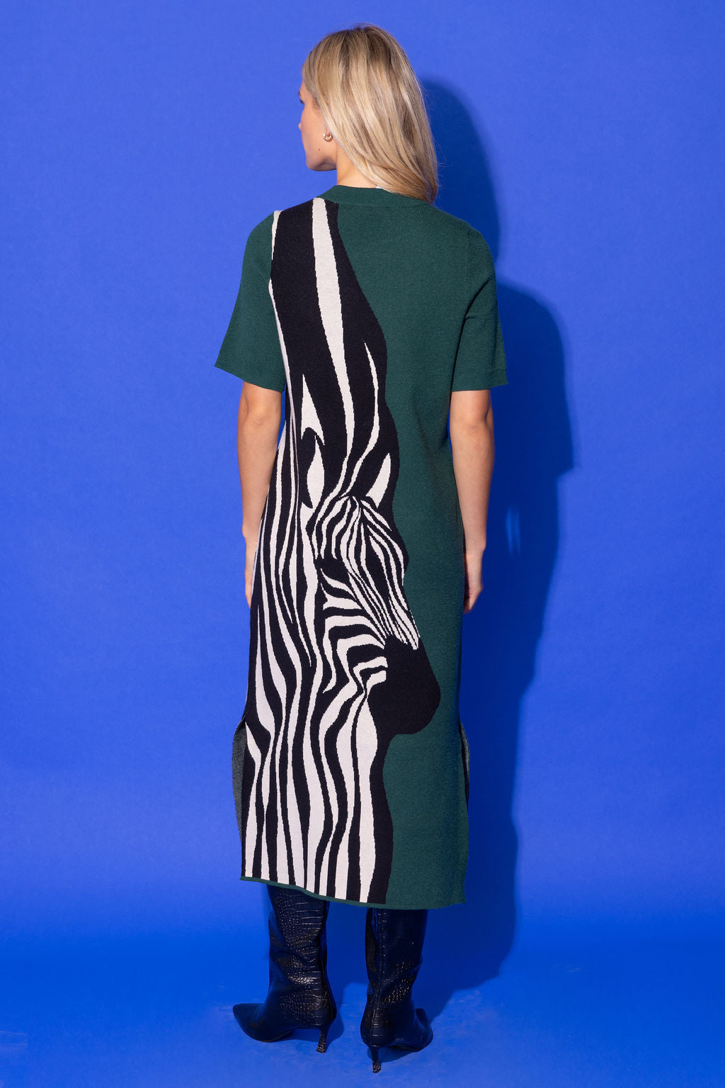 Alden Adair Scout Dress in forest green with bold black-and-white zebra silhouette graphic, back view on model with black boots.